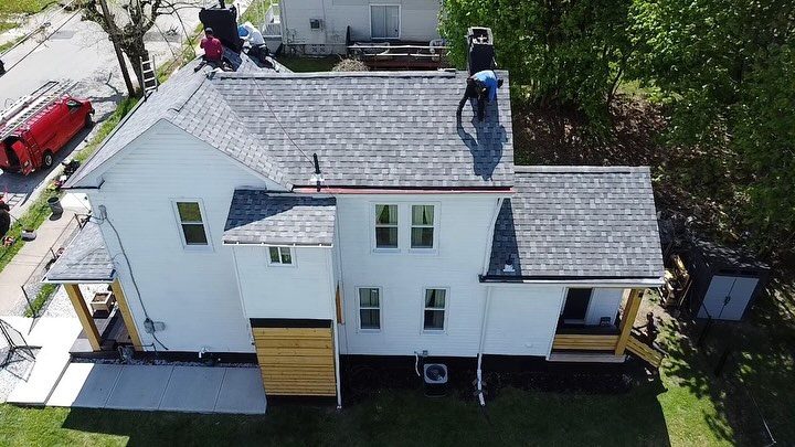 Roof repair in progress on a residential home, showcasing workers installing shingles, emphasizing exterior upgrades and maintenance services offered by Alan Construction.