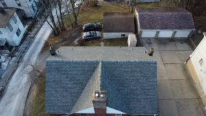 Aerial view of a residential roof in Pittsburgh, showcasing asphalt shingles and surrounding properties, relevant to roofing maintenance and replacement in local neighborhoods.