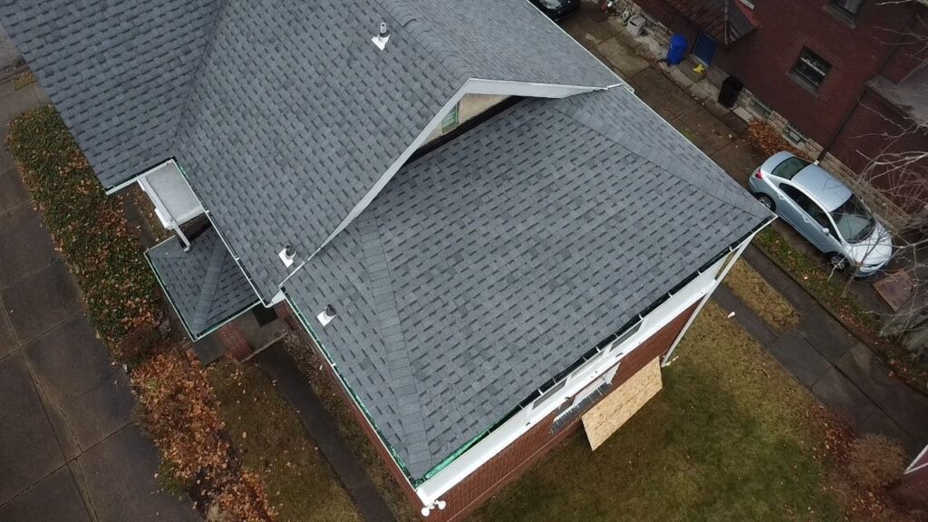 Aerial view of a residential roof featuring architectural shingles, showcasing a well-maintained structure in a Pittsburgh neighborhood, emphasizing curb appeal and quality roofing.