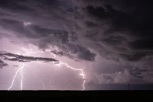 Dramatic lightning striking during a thunderstorm, highlighting the importance of roof maintenance in Pittsburgh homes.