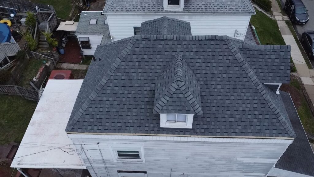 Aerial view of a townhouse roof in Pittsburgh featuring gray shingles and a complex design, highlighting roofing solutions relevant to local homeowners.