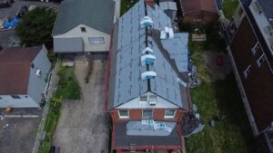 Aerial view of a residential roof under construction in Pittsburgh, showcasing new roofing materials and installation process, relevant to roof replacement and maintenance for homeowners.