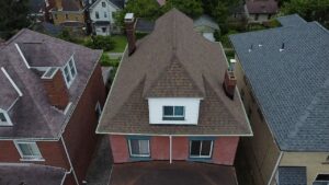 Aerial view of a residential home in Pittsburgh showcasing a well-maintained roof and surrounding neighborhood architecture.