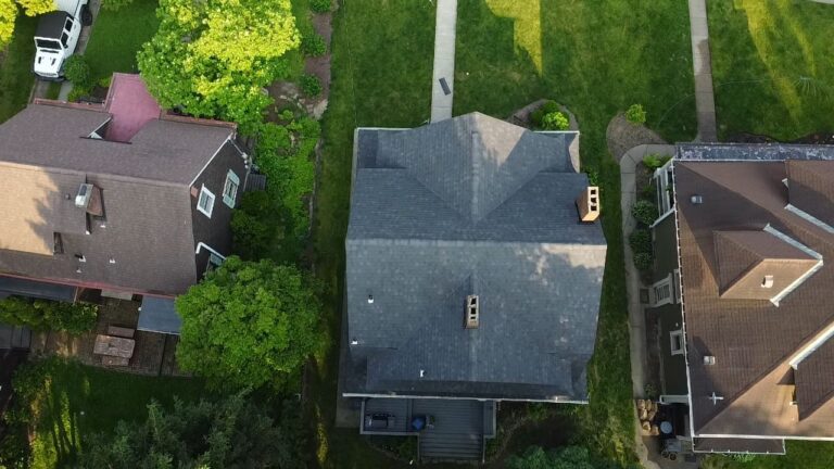 Aerial view of residential roofs in Pittsburgh, showcasing well-maintained shingles and surrounding greenery, relevant to home exterior services and roofing projects.