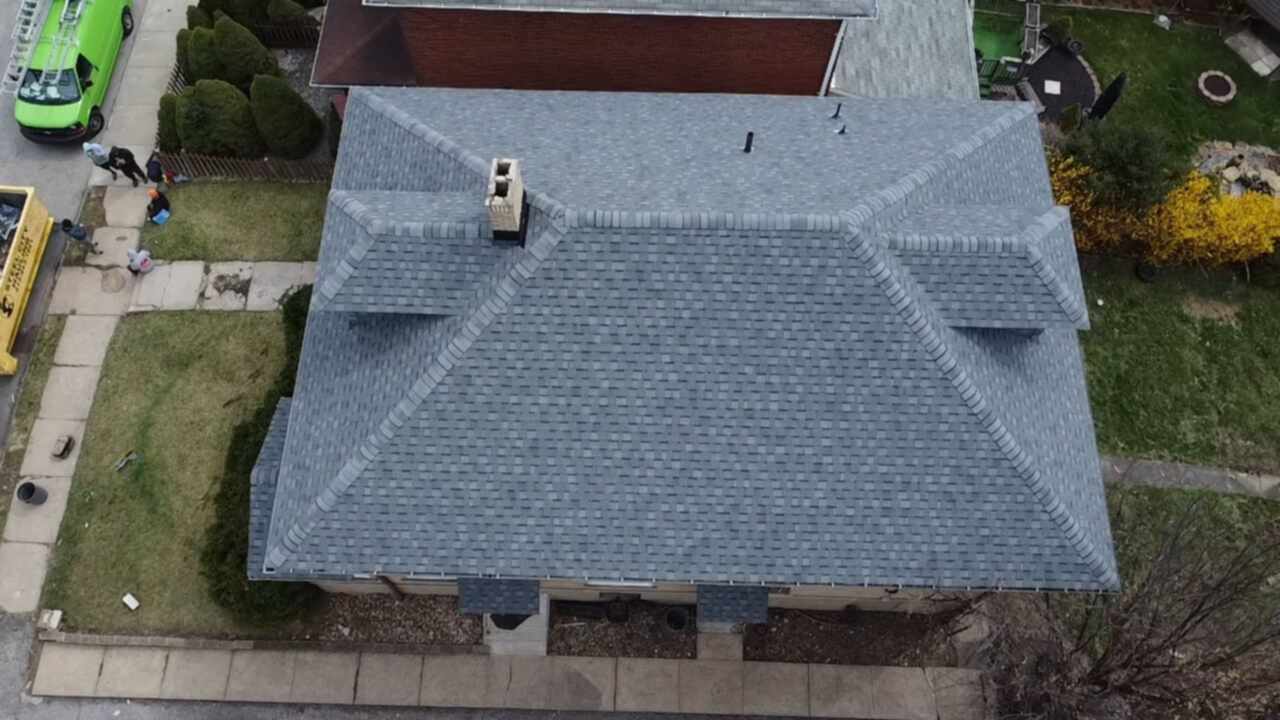 Aerial view of a newly shingled roof with gray shingles, showcasing a well-maintained residential property in Pittsburgh, highlighting roofing quality and craftsmanship by Alan Construction.
