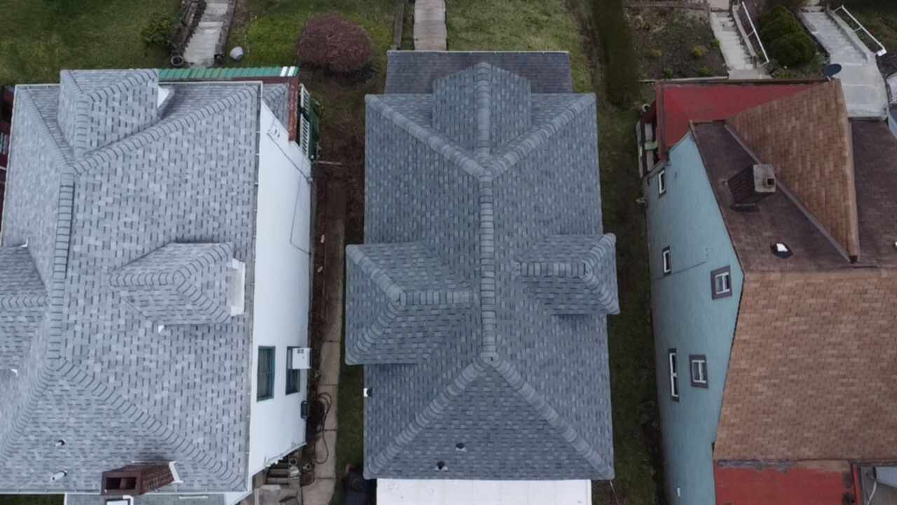 Aerial view of multiple residential roofs showcasing modern asphalt shingles, emphasizing quality roofing work relevant to Alan Construction's repair and replacement services in Pittsburgh.