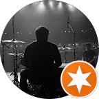 Drummer performing on stage with spotlight effects, emphasizing live music atmosphere and energy.