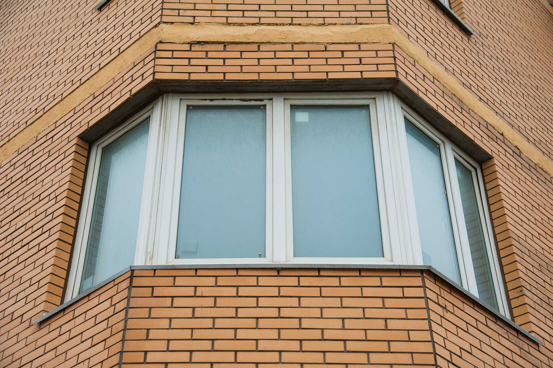 Modern energy-efficient bay window on a brick facade, showcasing quality window replacement services by Alan Construction in Pittsburgh.
