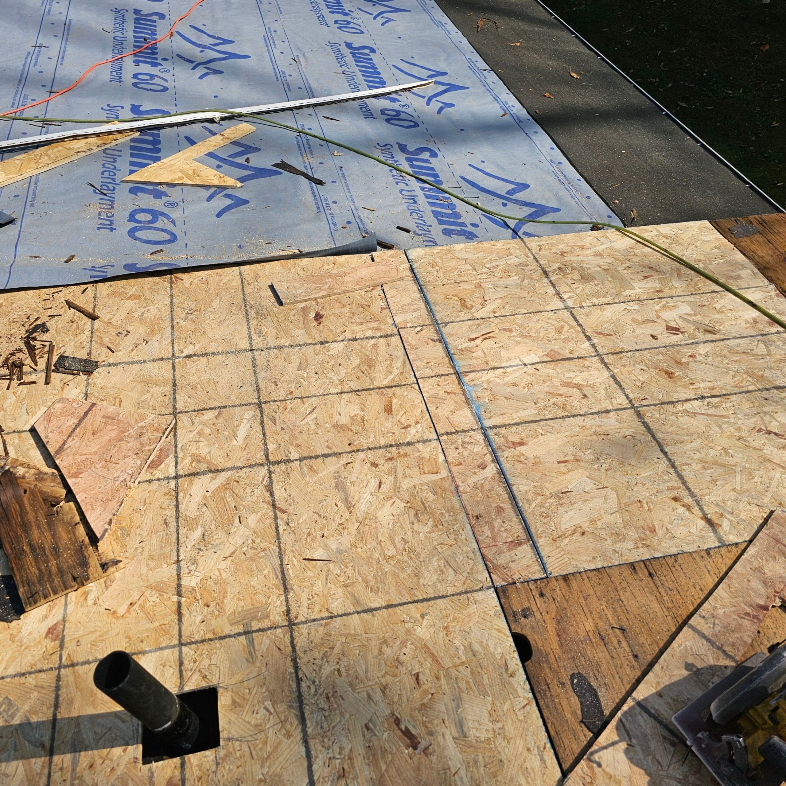 Newly installed roof decking with protective underlayment and marked grid for precise installation during complete roof replacement project by Alan Construction in Natrona Heights.