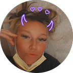 Person with playful expression and decorative heart-shaped filters, wearing a face mask, reflecting a lighthearted mood.