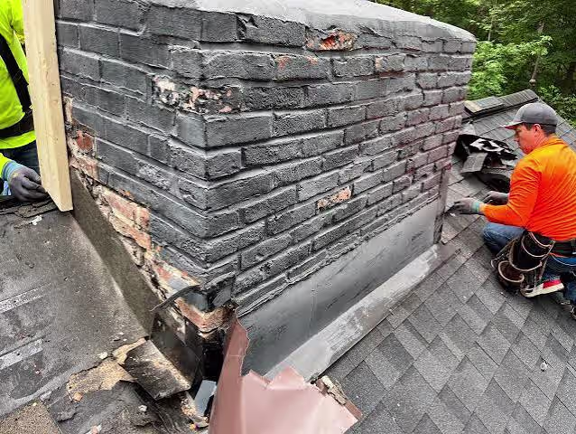Roof repair crew replacing damaged chimney flashing and working around deteriorated brickwork.