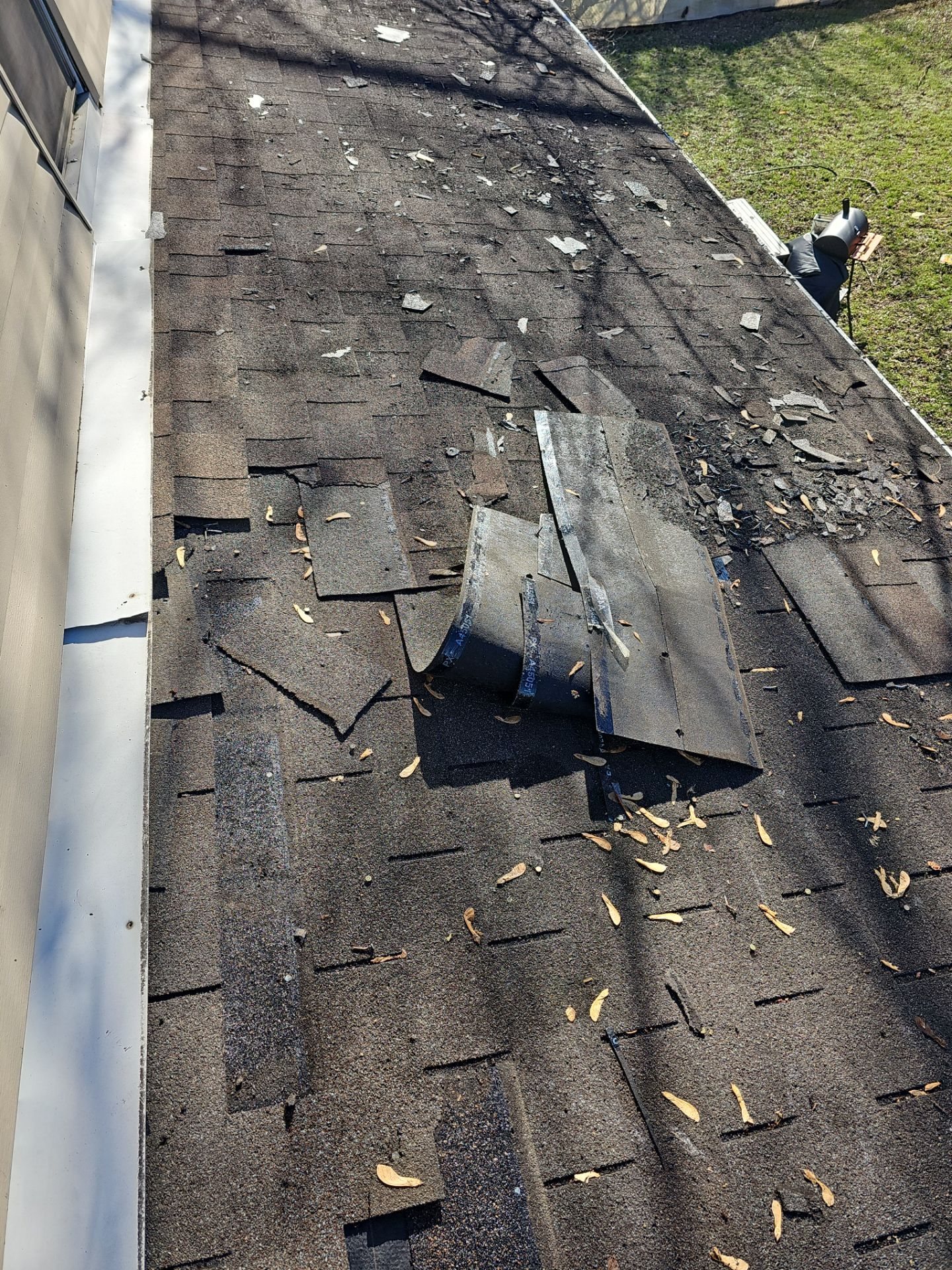 Old shingles lifting and broken along a gutter in East Pittsburgh, Alan Construction