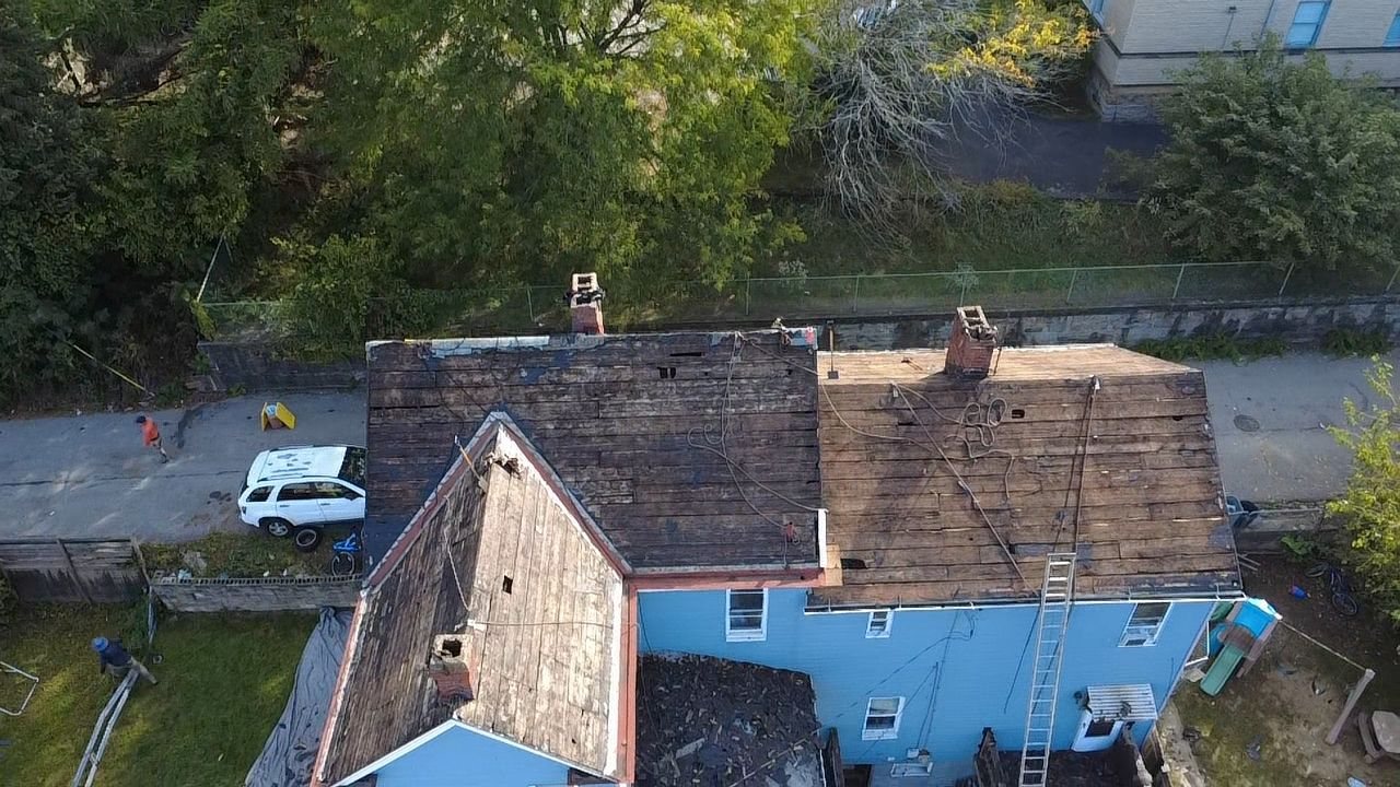 Drone view of an old weathered brown roof before replacement in Glassport, Alan Construction
