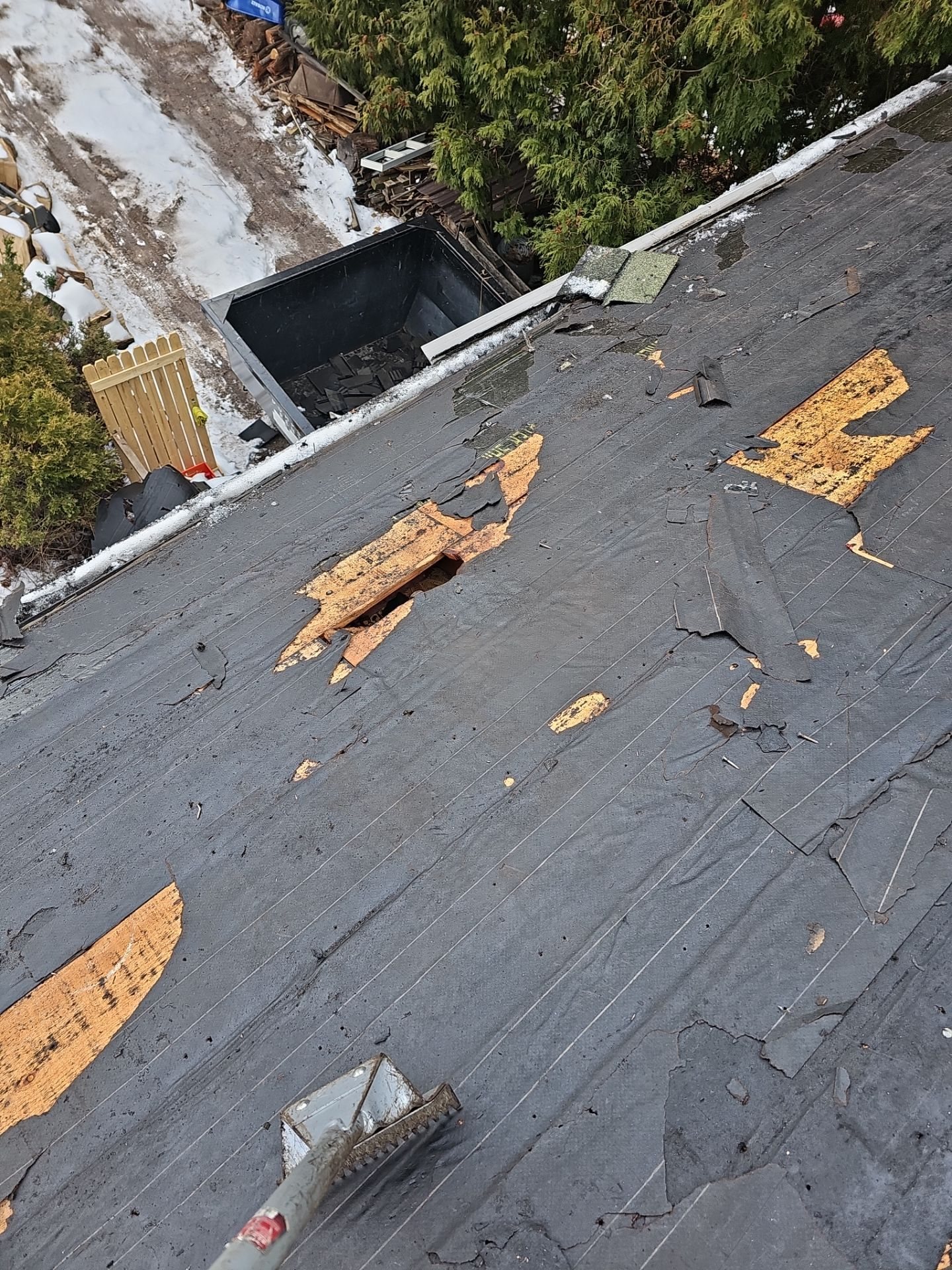 Worn low slope roof with torn patches exposing the deck in Pittsburgh, Alan Construction