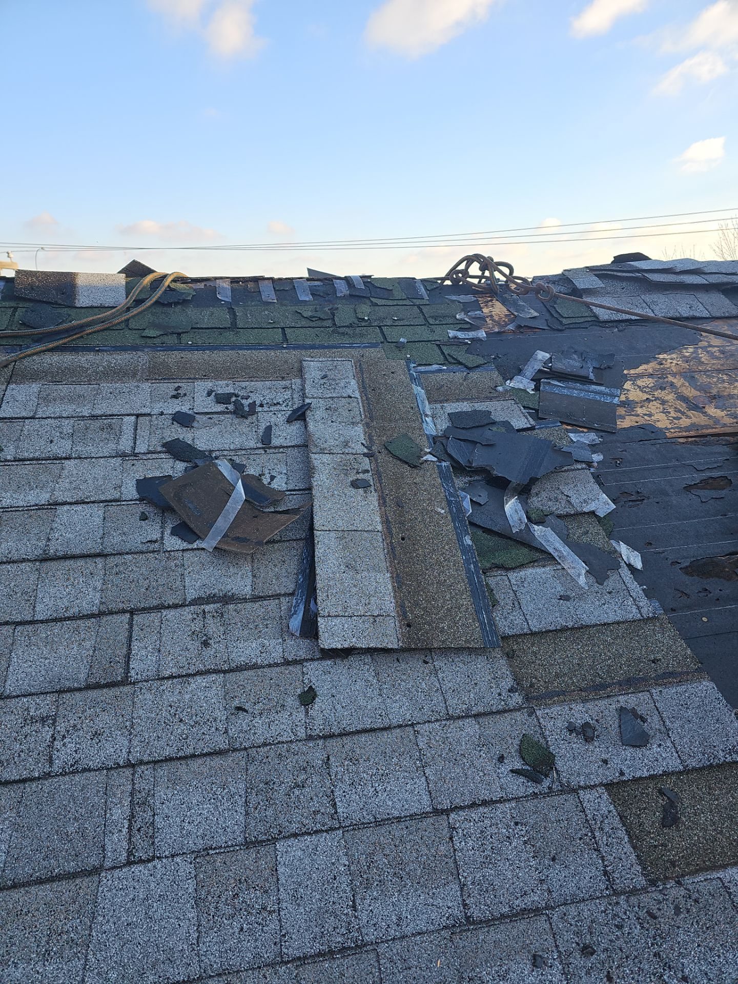 Worn gray shingle roof with loose and missing pieces before replacement in Pittsburgh, Alan Construction