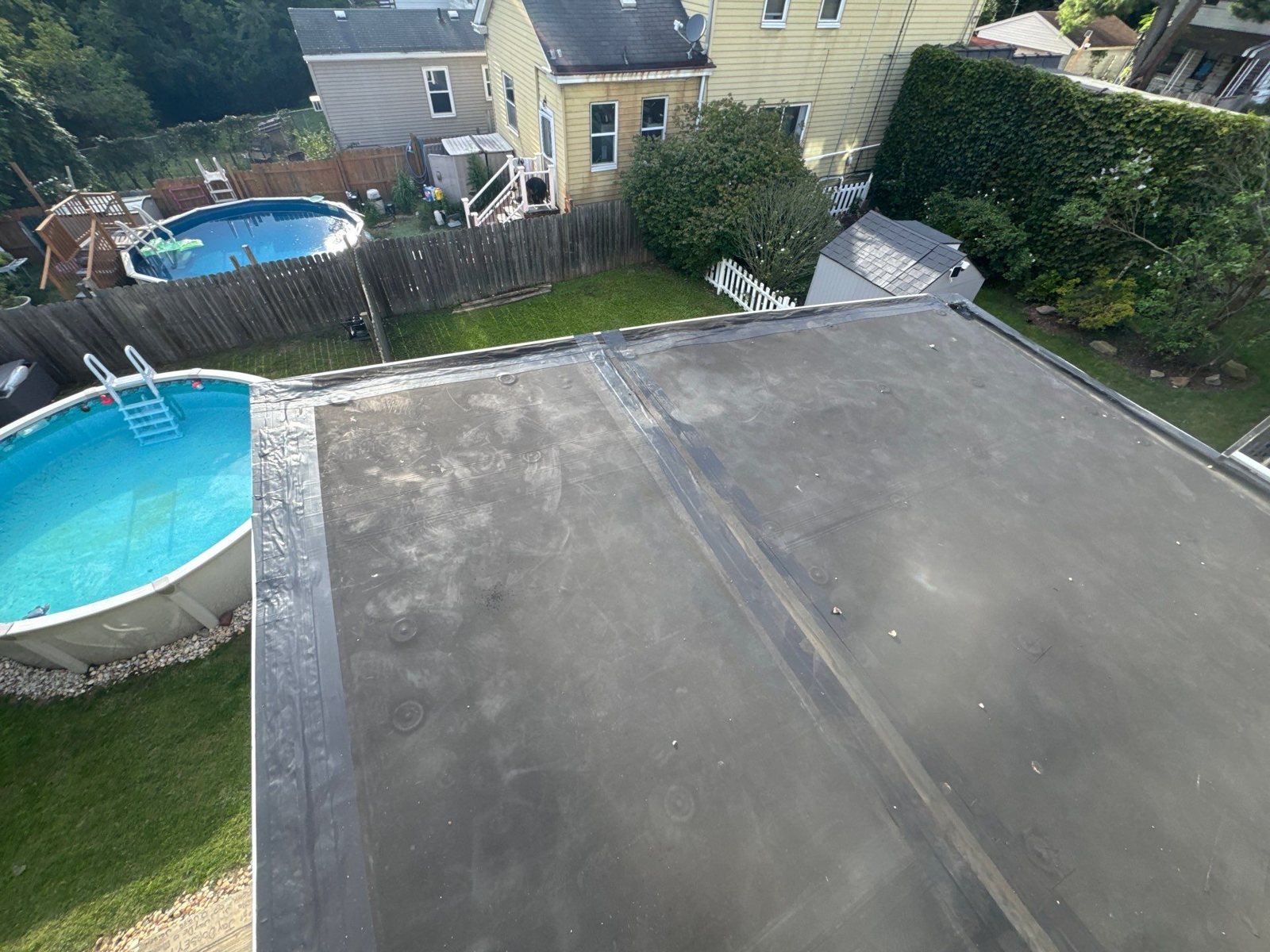 Black rubber flat roof over a back addition beside a backyard pool in Pittsburgh, Alan Construction