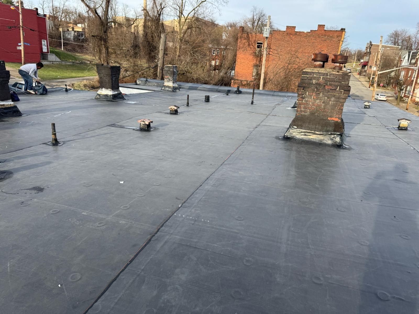 Finished black membrane flat roof with pipe flashings and chimney in Pittsburgh, Alan Construction