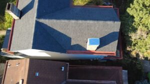 Drone view of a new dark gray shingle roof with red trim in Bethel Park, Alan Construction