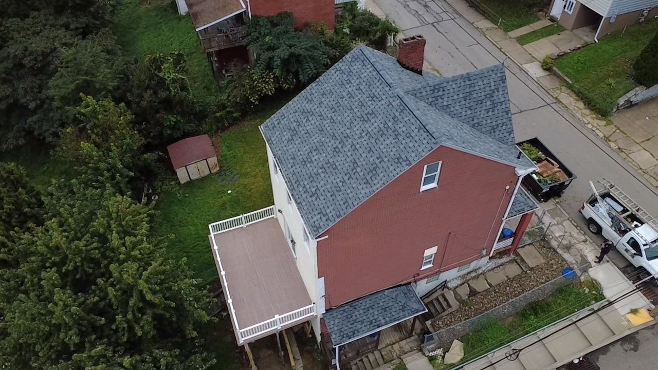 Drone view of a brick house with a new gray shingle roof in Pittsburgh, Alan Construction