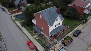 High drone view of a finished gray shingle roof on a two story home in Pittsburgh, Alan Construction