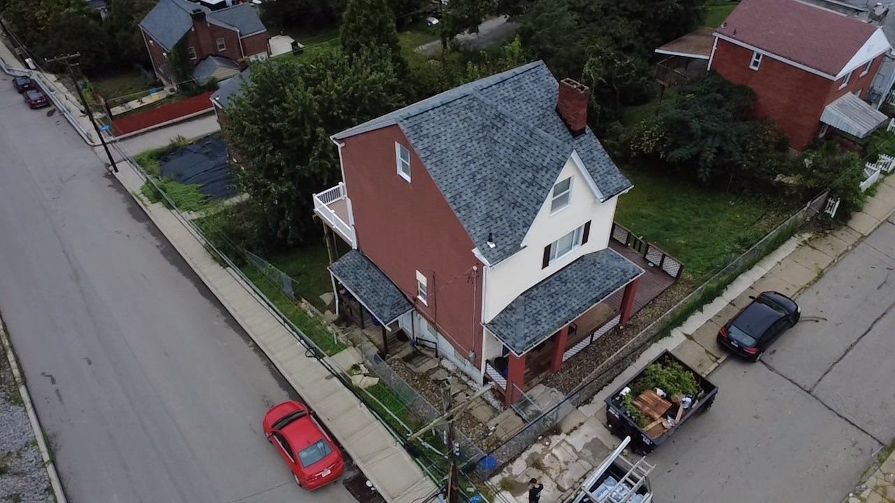 High drone view of a finished gray shingle roof on a two story home in Pittsburgh, Alan Construction