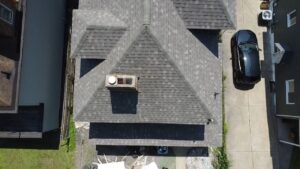 Top down drone view of a finished gray shingle roof with a chimney in Pittsburgh, Alan Construction