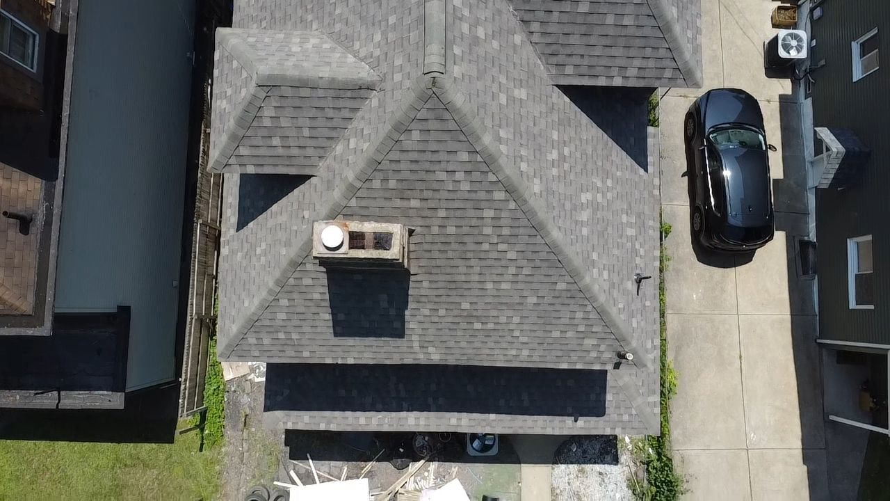 Top down drone view of a finished gray shingle roof with a chimney in Pittsburgh, Alan Construction