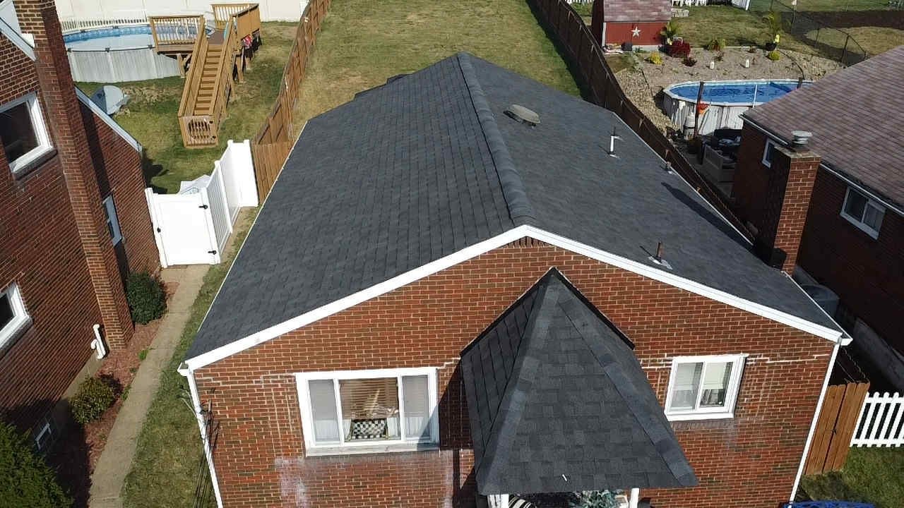 Drone view of a new dark gray shingle roof on a brick ranch home in West Mifflin, Alan Construction
