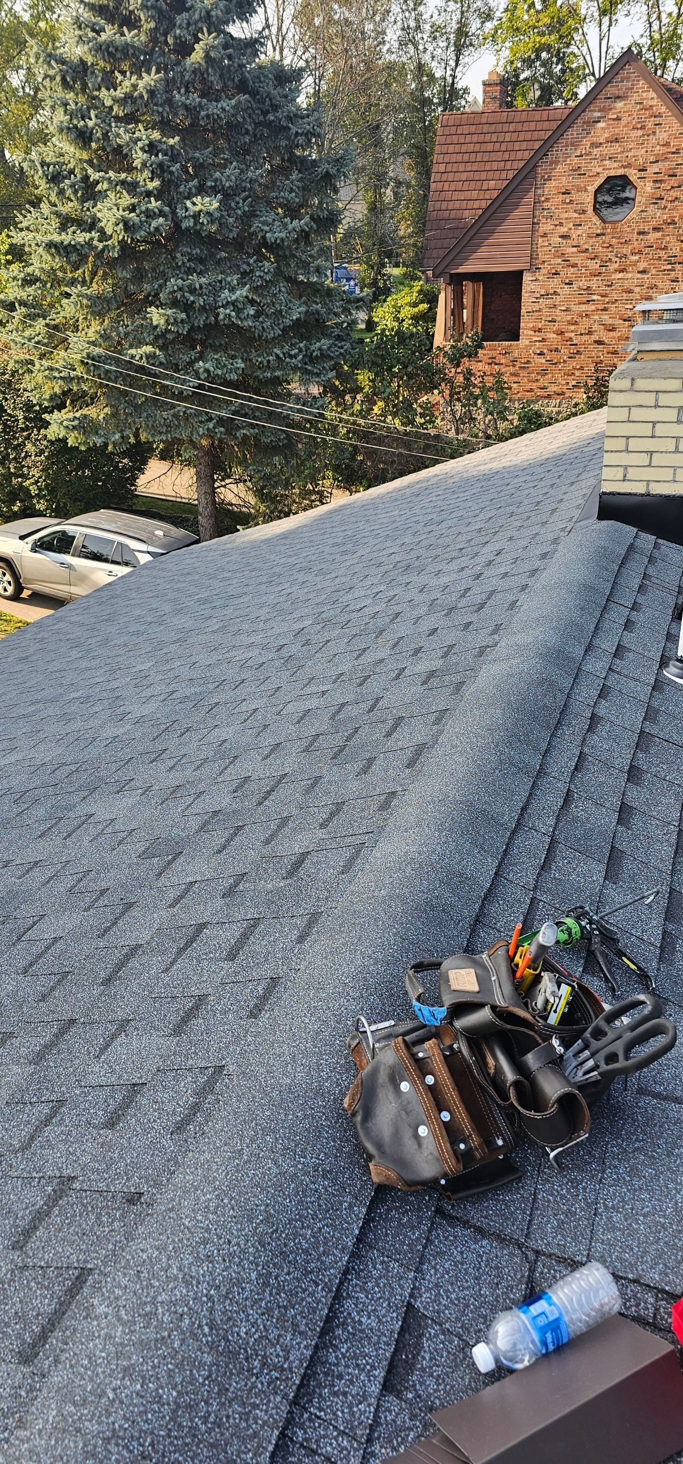 New gray shingles with a roofer tool bag on the slope in Bethel Park, Alan Construction