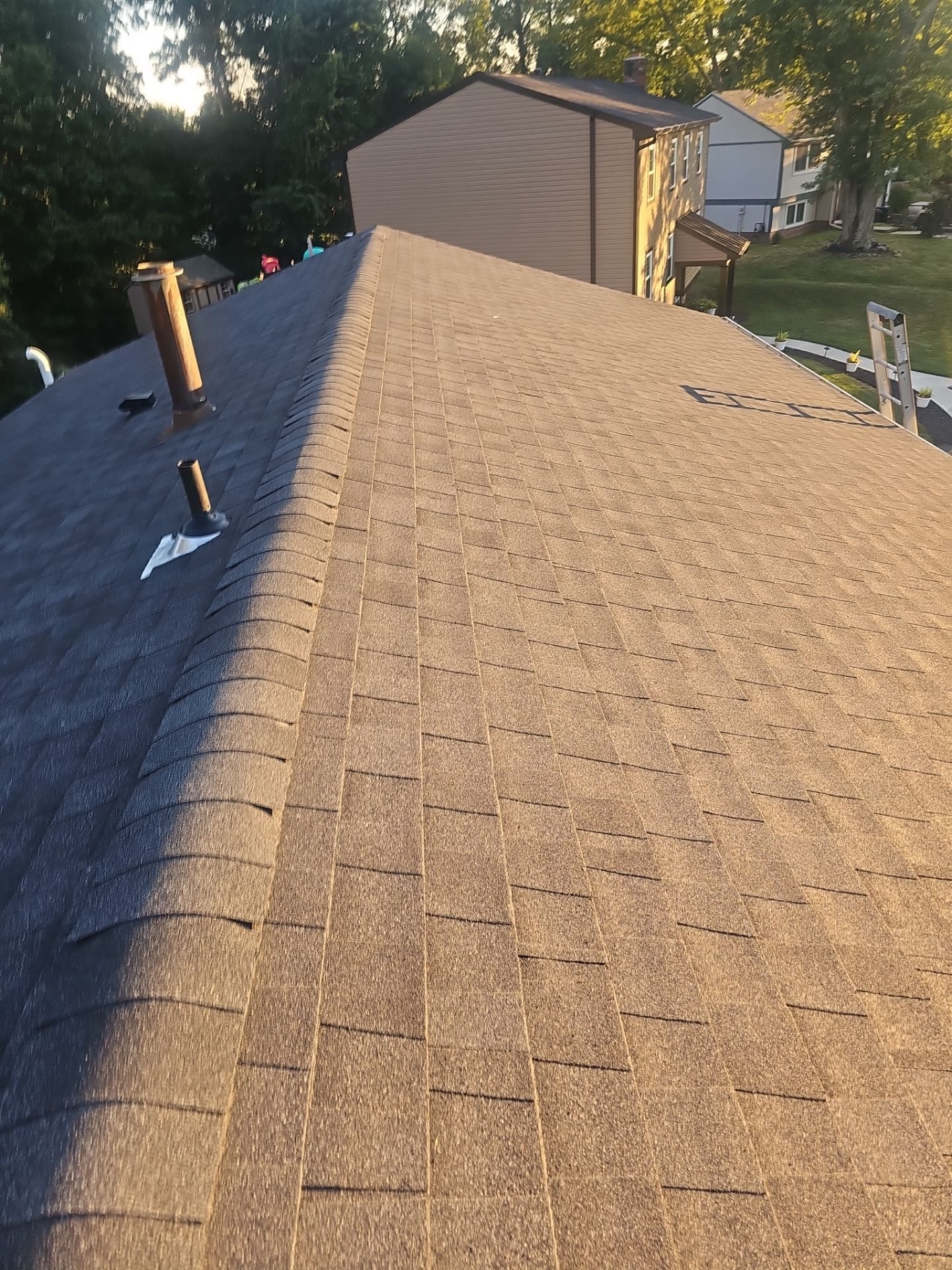 New brown shingle roof slope with ridge line and vent stack in Pittsburgh, Alan Construction