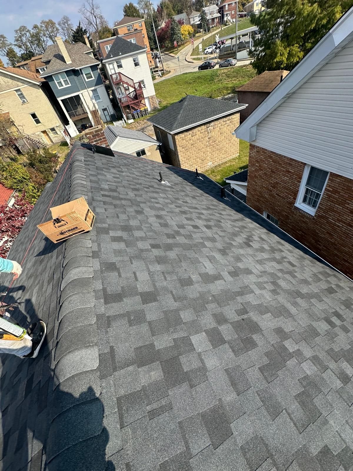New gray shingles running down a roof toward the street in Pittsburgh, Alan Construction