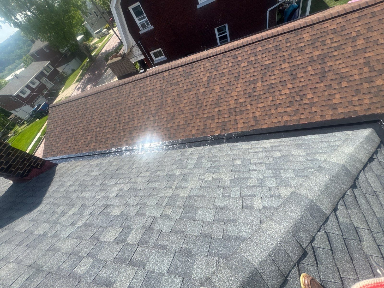 New gray shingle roof meeting an upper brown shingle roof in Pittsburgh, Alan Construction