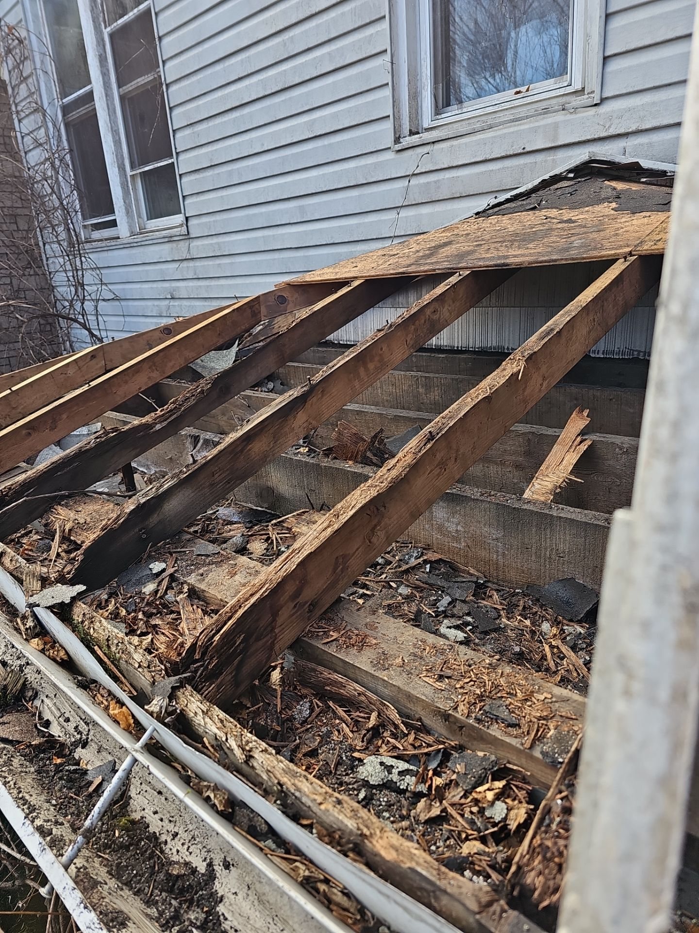Exposed rafters and rotted boards on a porch roof against siding in Turtle Creek, Alan Construction