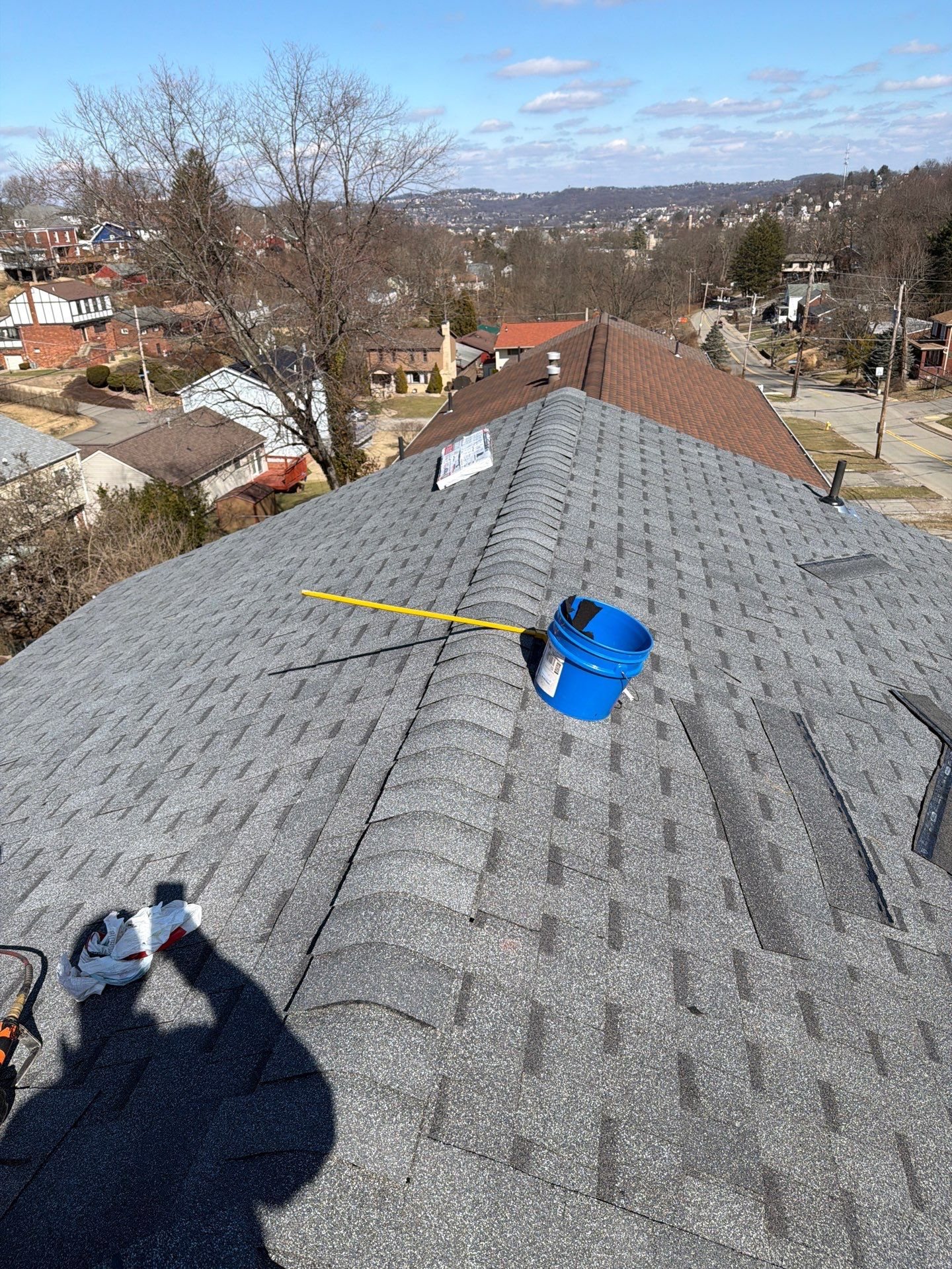 Nearly finished gray shingle roof with a chalk line and tools in Pittsburgh, Alan Construction