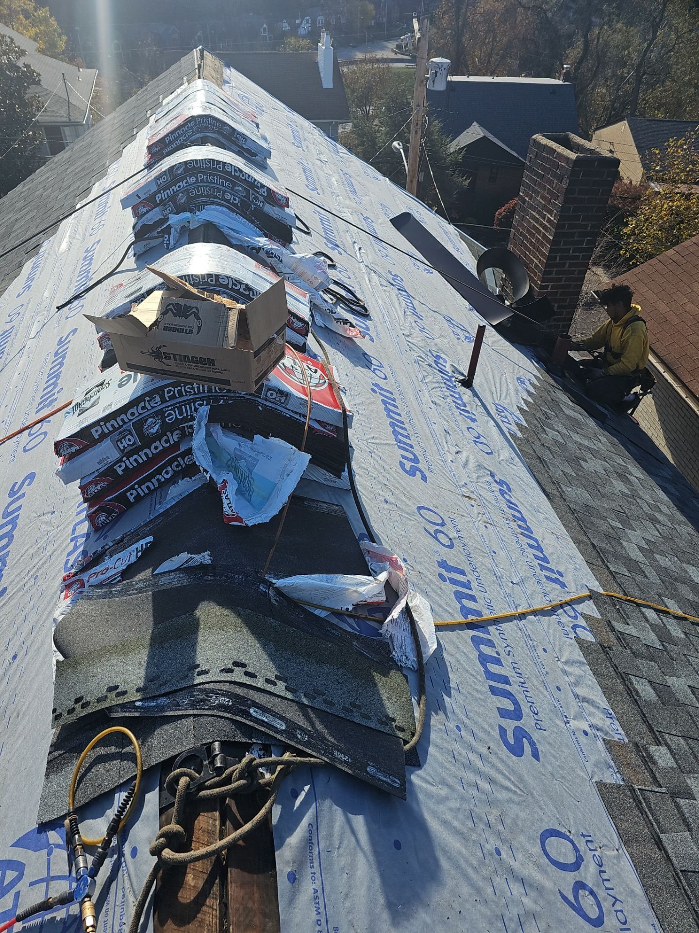 Shingle bundles staged along the ridge over underlayment in Pittsburgh, Alan Construction