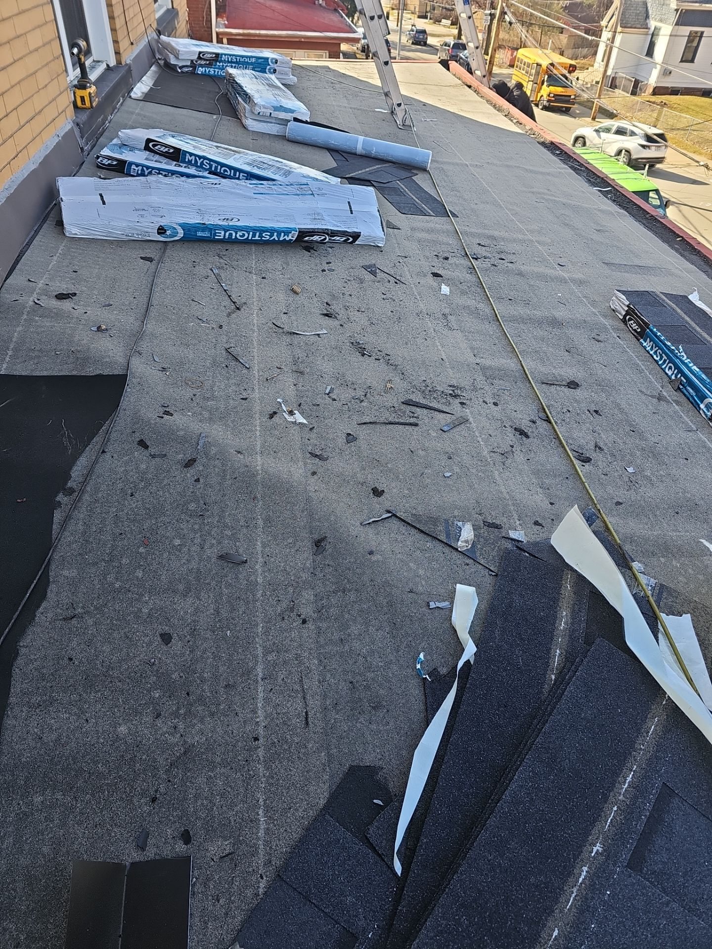 New shingles going on over underlayment with bundles staged above in Pittsburgh, Alan Construction