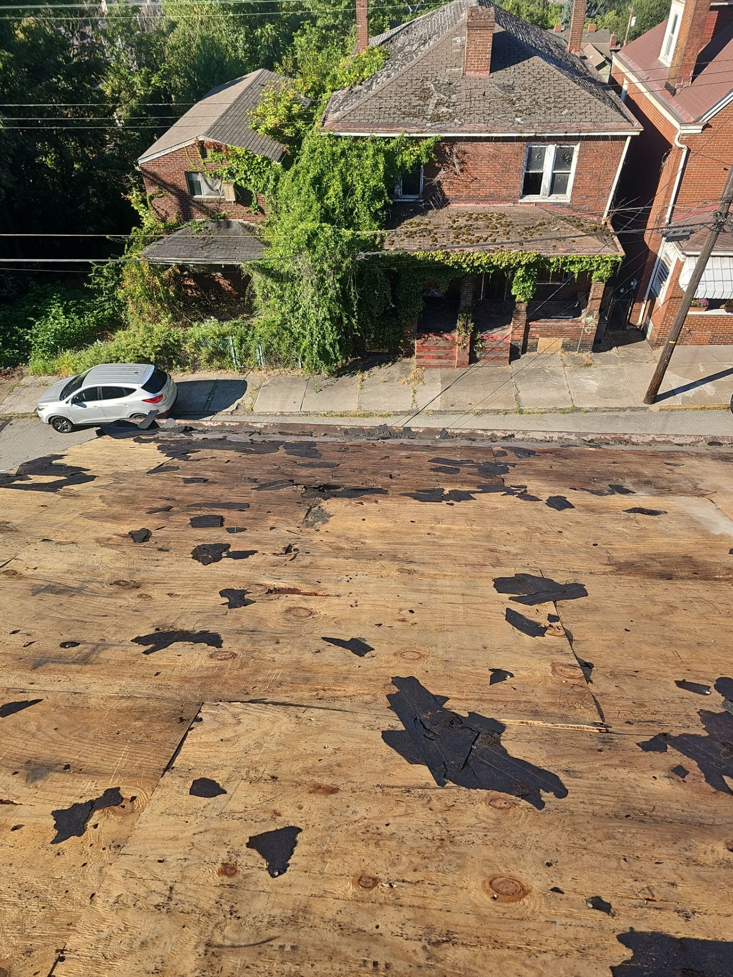 Roof deck exposed with scraps of old felt after tearoff in Braddock, Alan Construction