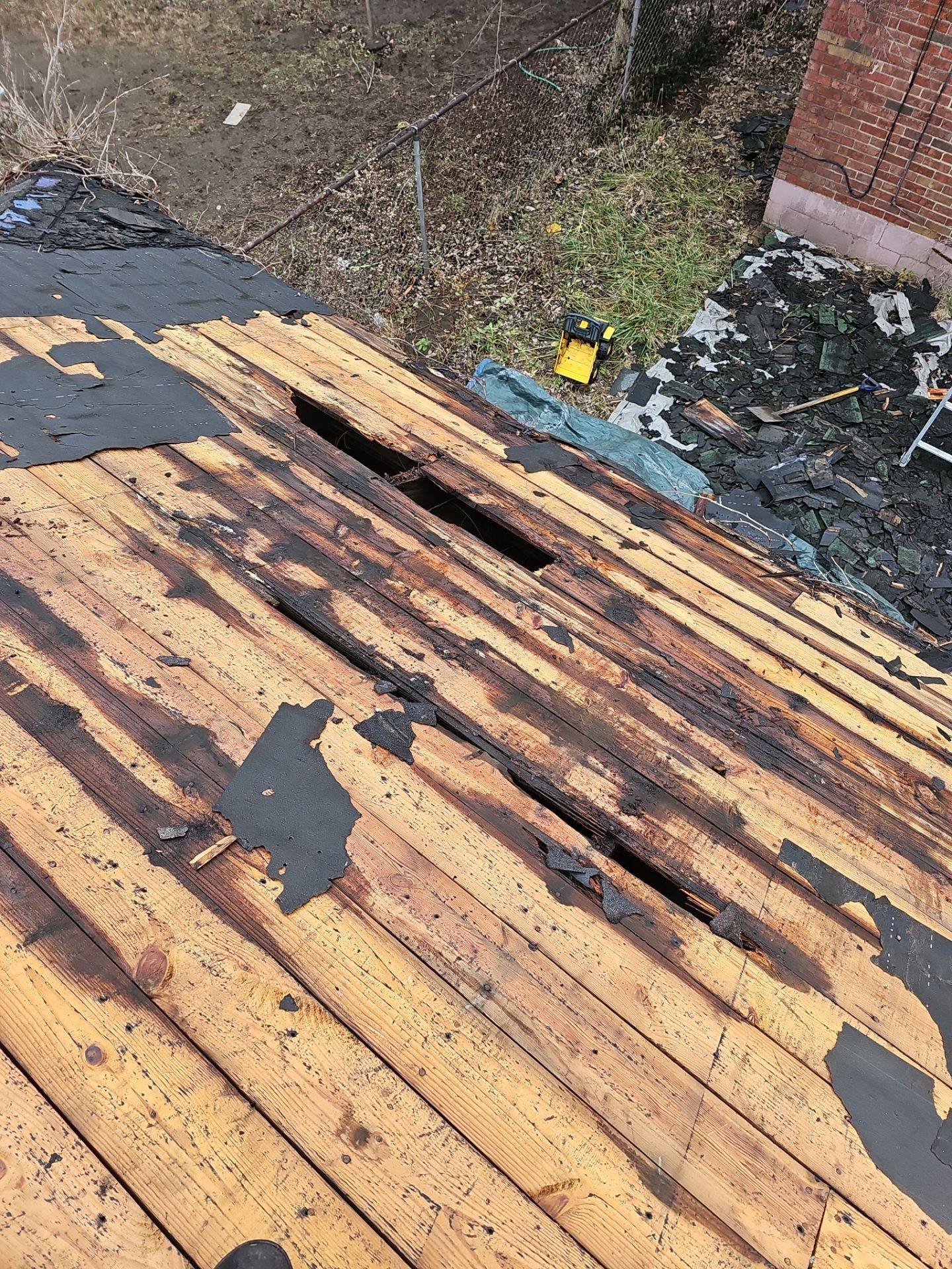 Old plank deck with holes exposed after shingle removal in Clairton, Alan Construction