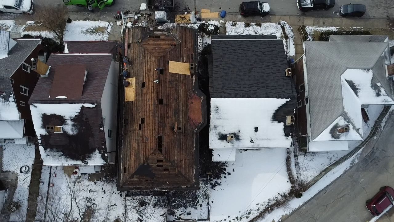 Drone shot of a row house roof stripped to bare boards in Pittsburgh, Alan Construction