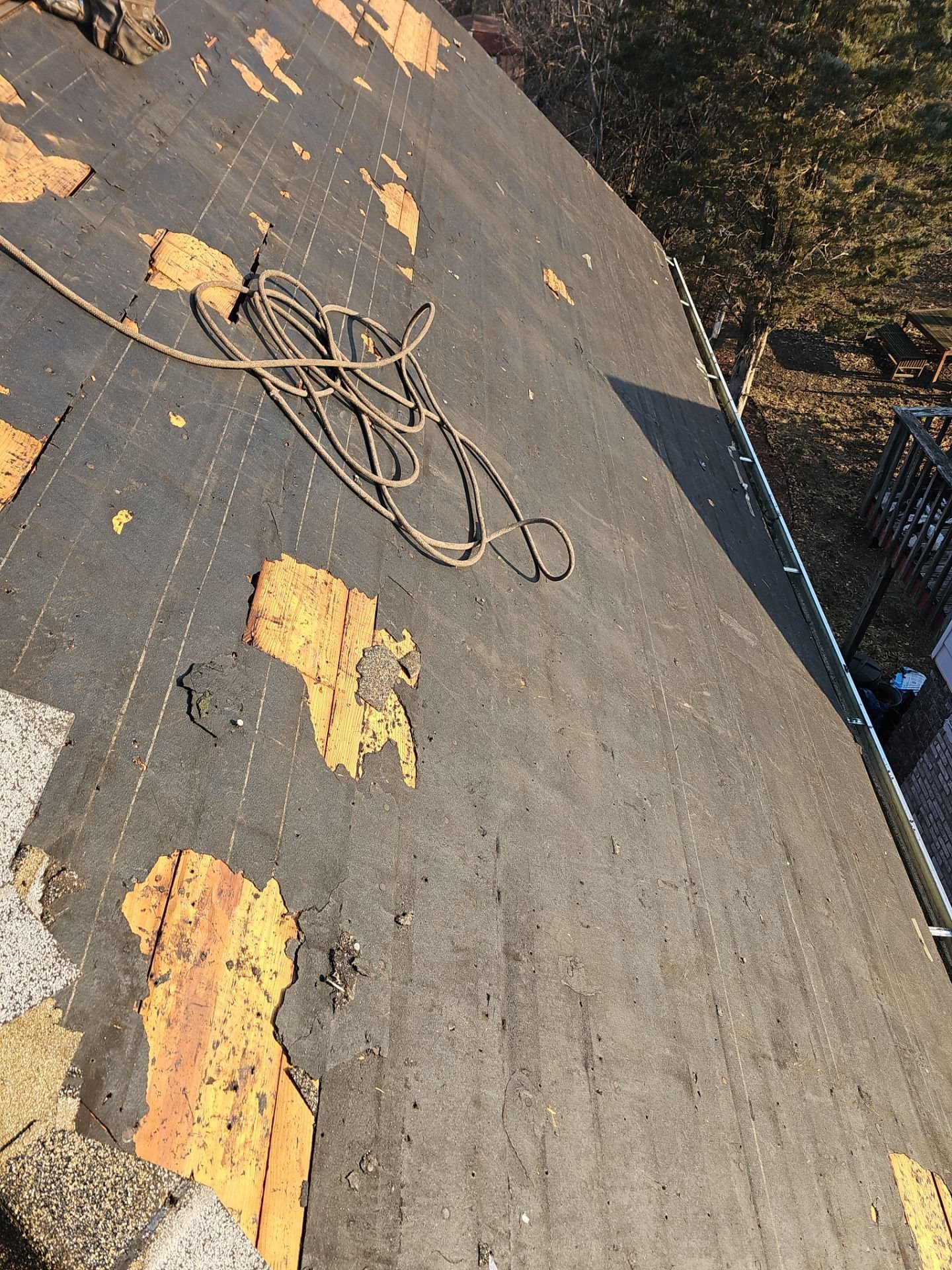 Roof deck with old felt scraps after shingles were removed in Pittsburgh, Alan Construction