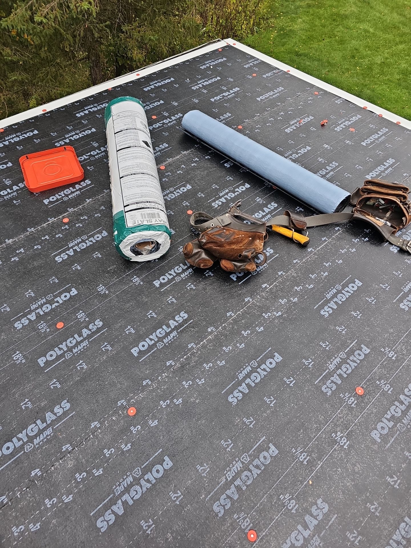 Self adhered underlayment with membrane rolls and tools on a low roof in Imperial, Alan Construction