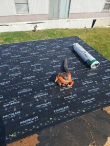 Black self adhered underlayment on a low slope roof with a roller tool in Oakdale, Alan Construction