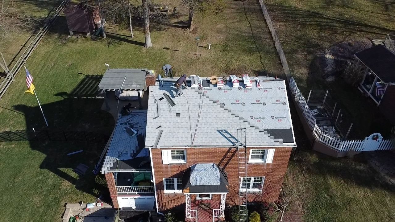 Drone view of a brick home with underlayment on the roof in Pittsburgh, Alan Construction