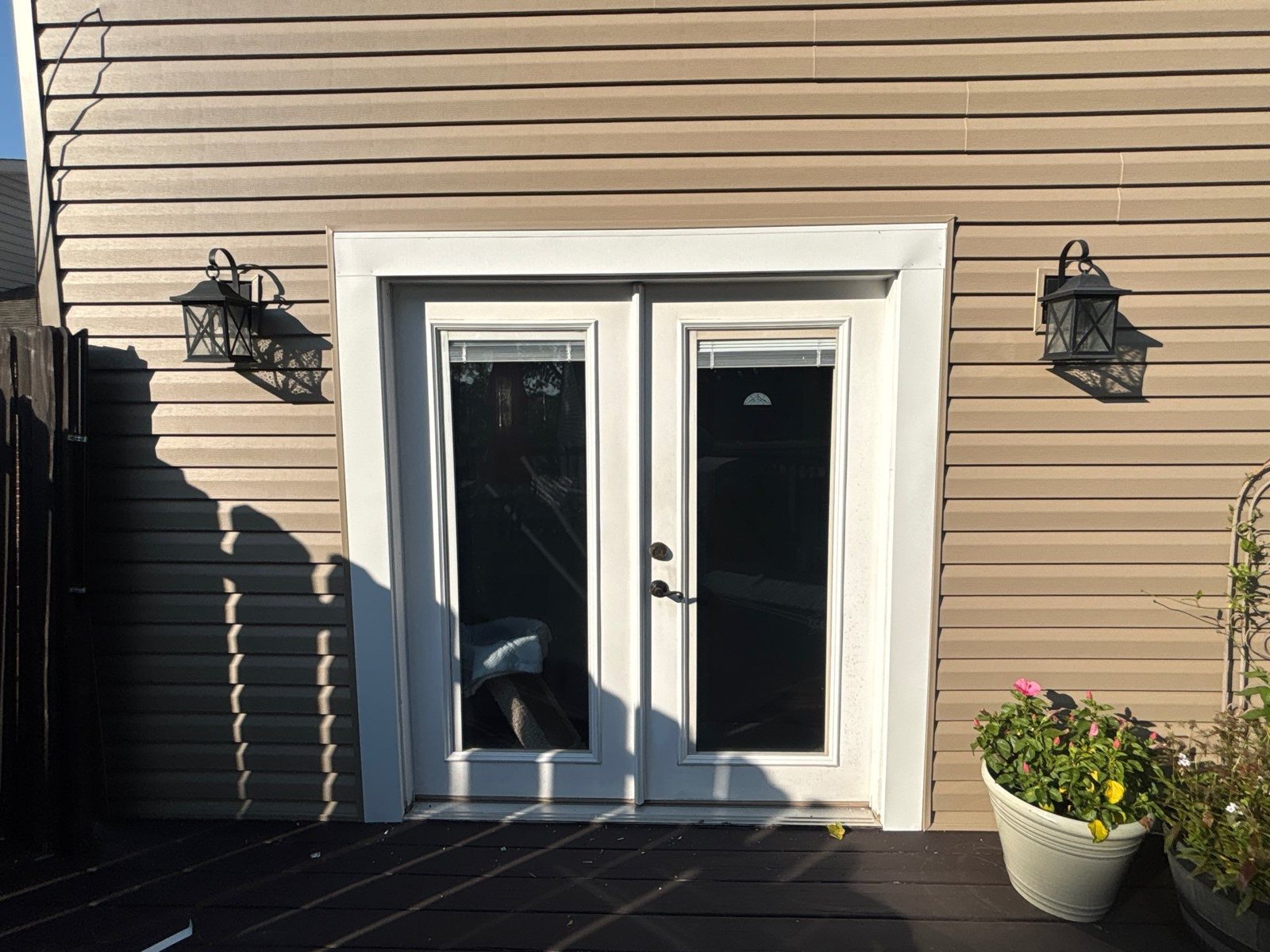 Tan vinyl siding around white French doors on a deck in Carnegie, Alan Construction