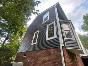 New dark gray vinyl siding on the upper story above a brick base in Pittsburgh, Alan Construction