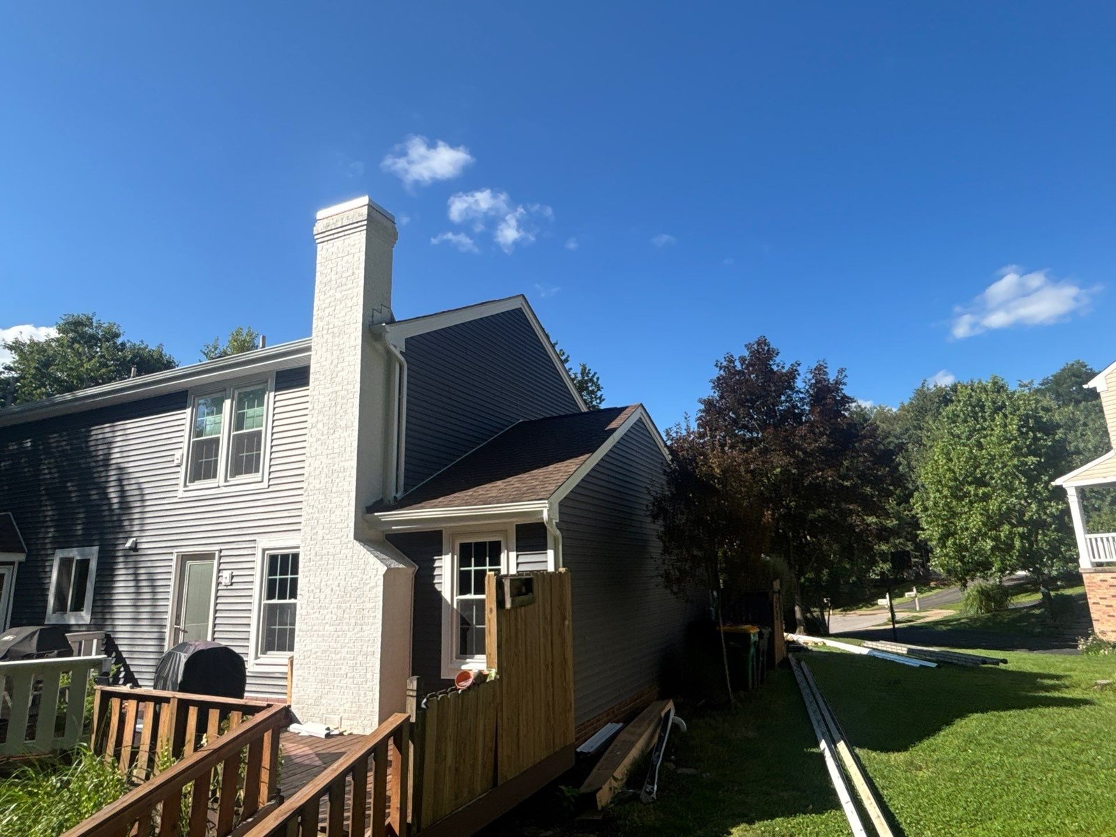 Gray vinyl siding on the back of a home with a deck and chimney in Pittsburgh, Alan Construction
