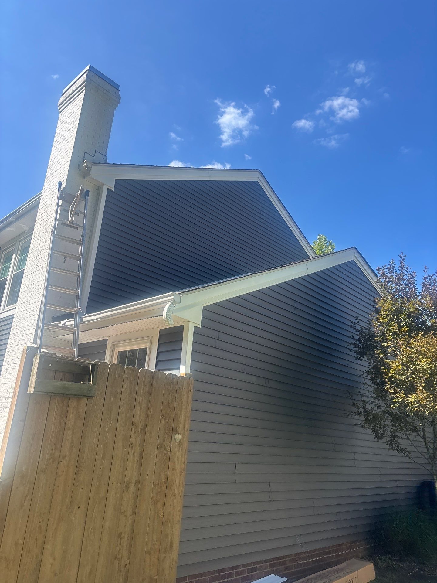 Gray siding gable wall beside a new wood privacy fence in Pittsburgh, Alan Construction