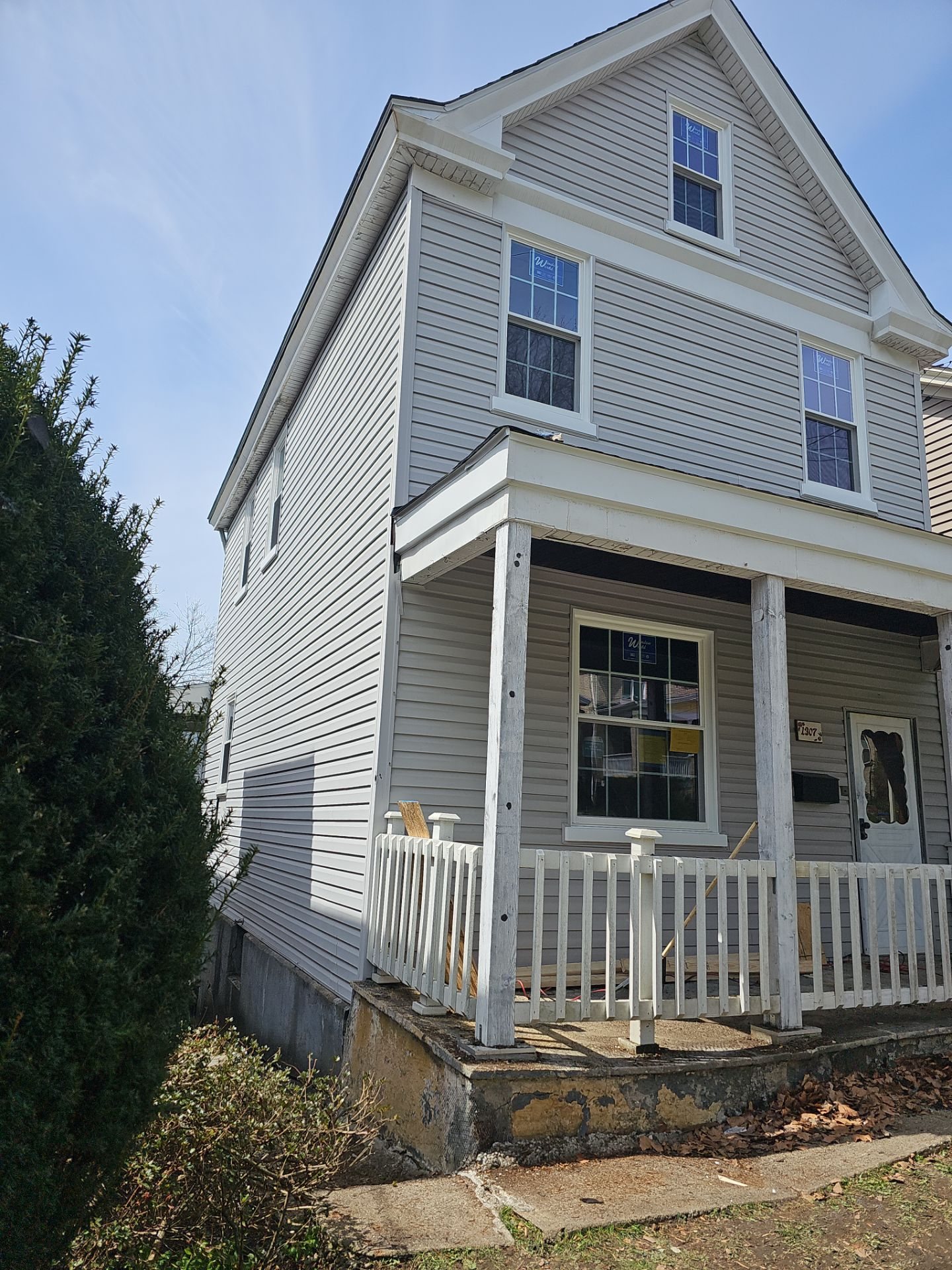 Two story house with gray siding and a white porch railing in Pittsburgh, Alan Construction