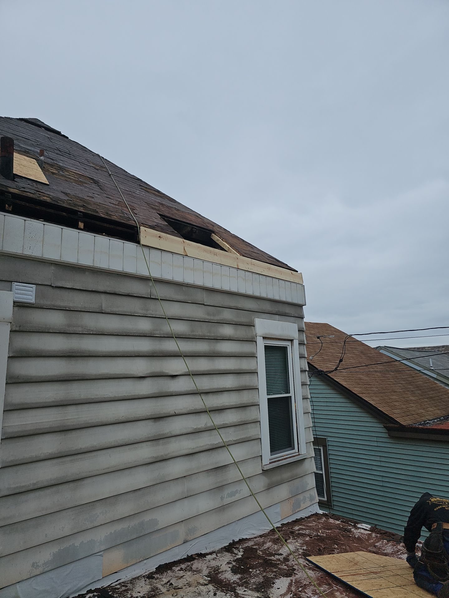 Gray siding wall below a roof edge with old decking in Pittsburgh, Alan Construction