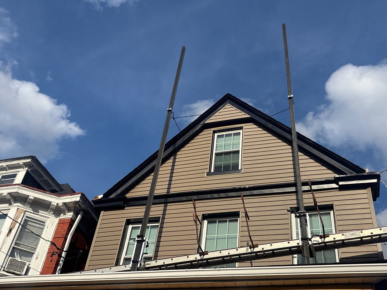 Gable end with new tan siding and black trim in Pittsburgh, Alan Construction